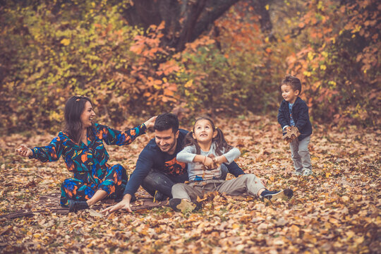 Happy smiling beautiful family playing and laugh in the forest