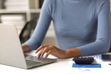 Naklejka premium Businesswoman working with laptop and financial documents on desk, financial and investment data analysis, financial planning and accounting.