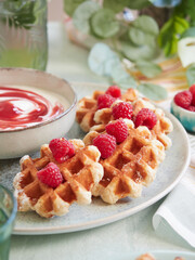 close-up view of waffles with fresh raspberries served on top