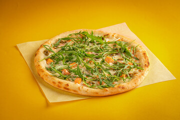Fresh classic pizza with tomato sauce, mozzarella, spicy chorizo, bell pepper on a yellow background