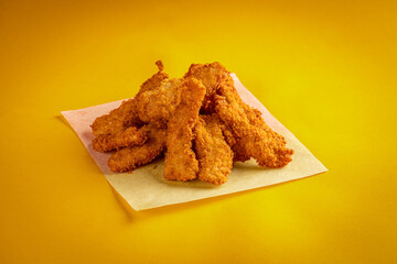 Fried chicken nuggets on a yellow background