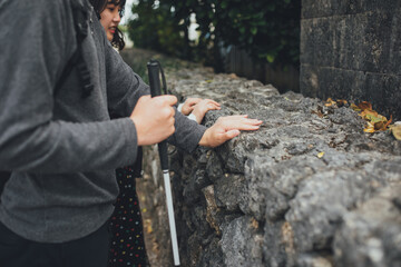 白杖を持った視覚障害者の男性が女性と沖縄を旅している