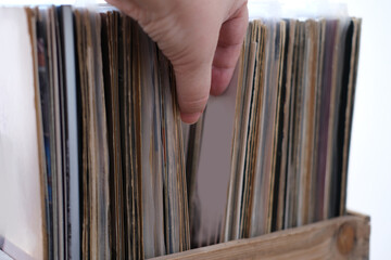 close-up of female hands, choosing vinyl records, antiques, old furniture, tables, used things,...