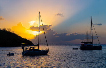 Sunset panorama at &ldquo;Anse Noir&ldquo; on the west coast of french overseas island Martinique. Sailing boats anchoring in the bay, a popular spot for diving in the Caribbean sea with big sea turtles.