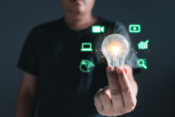 Man holding light bulb with icons, Marketers education, research, analyze media video streaming content creation and online marketing strategies to grow their digital business.