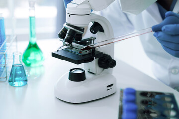 Chemist scientist holding test tube and tablet conducting experiment in laboratory with equipment, science concept.