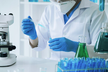 Fototapeta premium Chemist scientist holding test tube and tablet conducting experiment in laboratory with equipment, science concept.