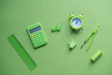 Stylish creative green stationery and school supplies on a green background. Back to school.