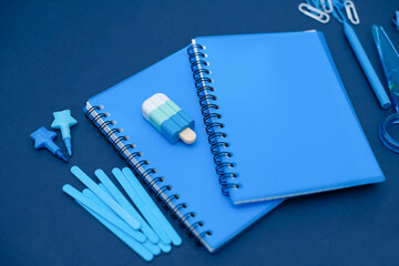 Stylish creative blue stationery and school supplies on a blue background. Back to school.