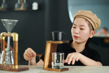 Young coffeeshop barista making Vietnamese style coffee for customer