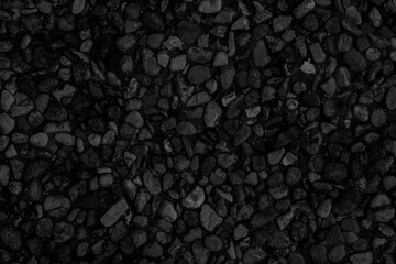 A sidewalk of black small stones. Fine pebble texture.