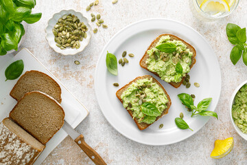 Avocado sandwich with pumpkin seeds. Healthy vegetarian avocado toast with rye bread for breakfast. Vegan menu. Top view - 604934819