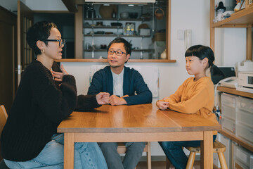 リビングで手話を使って会話をするろう者の父母とコーダの娘