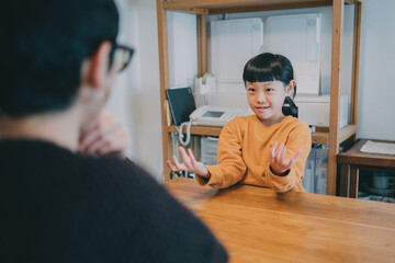 リビングでろう者の母親と手話で会話をする女の子