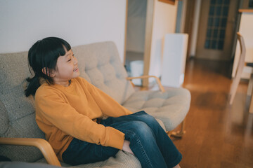Fototapeta premium 家の中で感情表現豊かに遊んでいる黄色い服を着たコーダの女の子