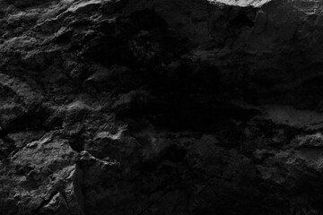 The black  texture of the stone is notched and mottled. holes notches grooves on the stone.