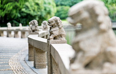 Row of stone lion statues on the edge of China pond