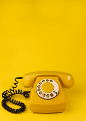 yellow bright retro telephone on a bright yellow background. for banners, advertisements, flyers, screensavers, covers, invitation cards, etc.
