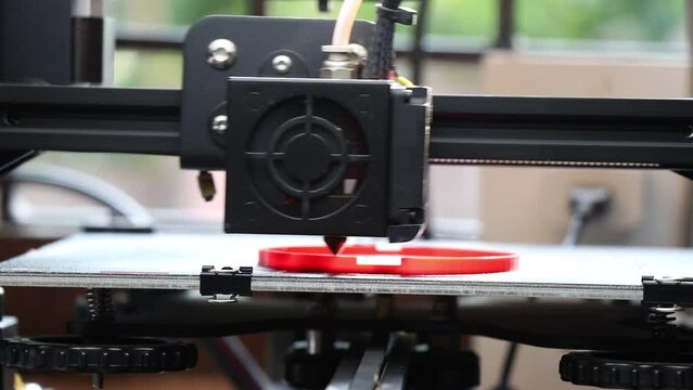 3D printer is printing some objects using a red pla filament