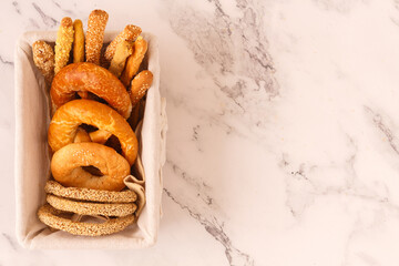 Freshly baked delicious bread, bagel, pretzel and breadsticks on a old rustic basket. Copy space. Top view. Healthy eating concept. Flat lay