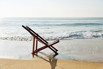 Fototapeta na wymiar An empty chair on the beach.