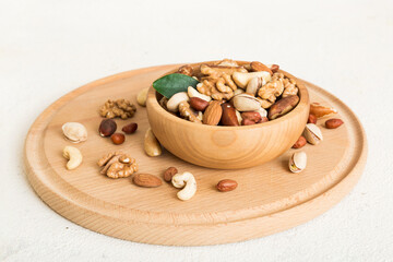 Fototapeta premium mixed nuts in bowl. Mix of various nuts on colored background. pistachios, cashews, walnuts, hazelnuts, peanuts and brazil nuts