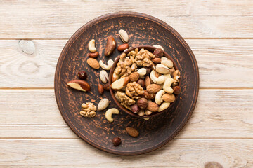 mixed nuts in bowl. Mix of various nuts on colored background. pistachios, cashews, walnuts, hazelnuts, peanuts and brazil nuts