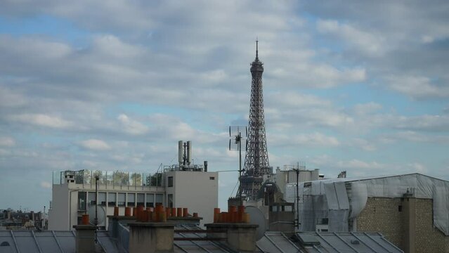 Remote view of Eiffel Tower from window of apartment on outskirts of city. Tracking shot of peaceful morning view of iconic Eiffel Tower in Paris through open hotel window. Travel and romance concept.