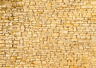 horizontal texture of an old wall made of rubble stone, brown sandstone and old plaster