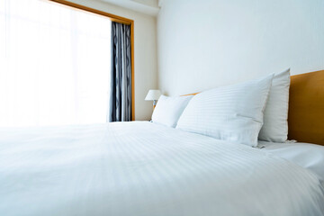 White bed sheet and pillows in hotel room