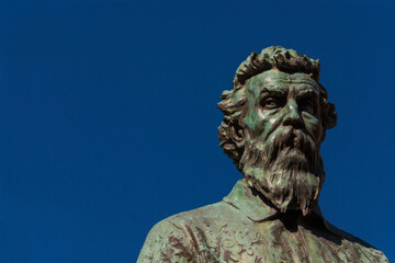 Obraz premium Benvenuto Cellini, a famous Italian Renaissance goldsmith and sculptor. Old bronze monument erected in 1901 on Ponte Vecchio (Old Bridge) in Florence (with blue sky and copy space)