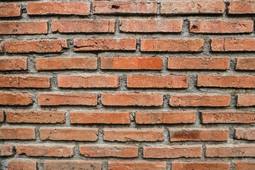 Texture of a red bricks wall. Old castle stone wall. Pattern red color of modern style design decorative uneven real stone wall surface with cement. Brick texture for wallpaper or background.