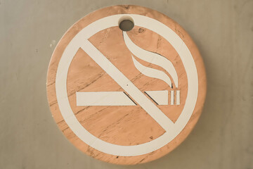 Round don't smoke sign. Wooden no smoking signage with gray walls background. Do Not Smoke in this...