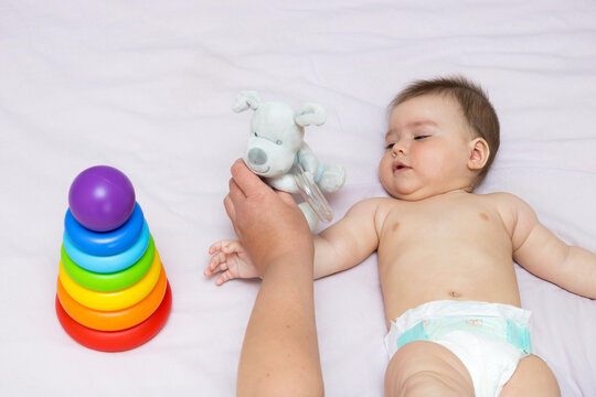 mother playing with baby daughter on bed