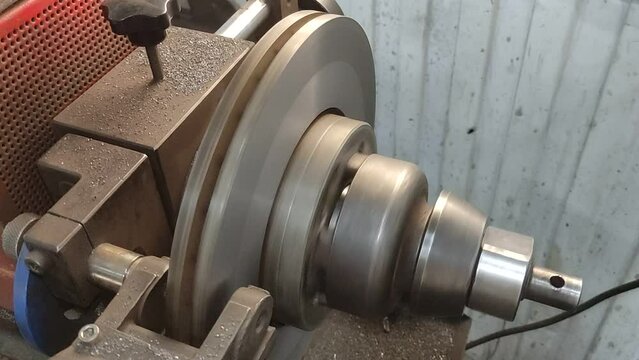 Car brake disc grinding on a turning machine. Brake discs runout fixing