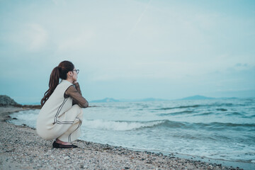 海で花束を手にしている皮膚の難病を持った女性