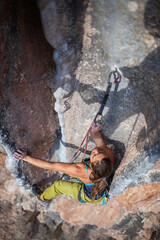 woman climbing big walls in the mountains, doing sports, striving hard for her goals without fear of success, courageous person, confident person with commitment.