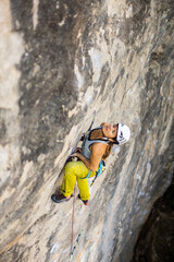 woman climbing big walls in the mountains, doing sports, striving hard for her goals without fear of success, courageous person, confident person with commitment.