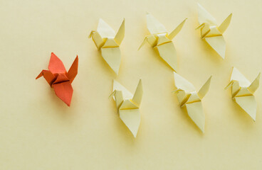 Origami paper cranes on yellow background