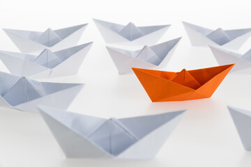 Orange paper boat stands out
