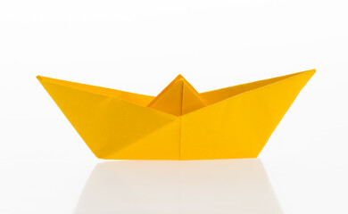 Yellow origami boat on white background