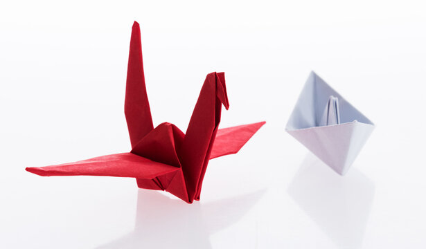 Origami boat and crane on white background