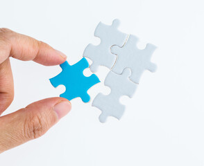 Hand put the blue piece in white puzzles