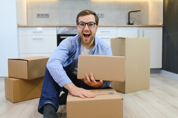 Fototapeta premium Smiling guy moving into his new home