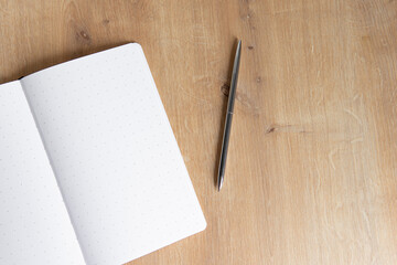 blank notebook and pen on the wooden table
