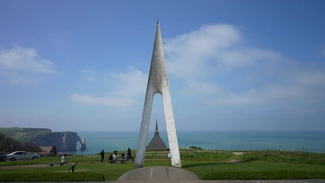 Front view of memorial to French aviators Nungesser and Coli, built in 1962, is overlooking Notre-Dame de la Garde chapel and the Aval cliff with the Needle and the arch, on background of sky and sea.