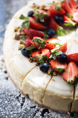 Meringue cake background. Top view cake. Fruit decorations. Red strawberries and raspberries on Pavlova whipped cream cake. Sweet dessert round cake. Decorated with berries.