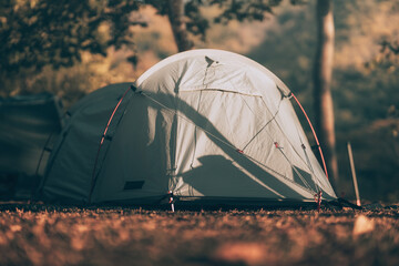 Gray tent on the grass in the forest The view behind is the mountain in the morning. Camping,...