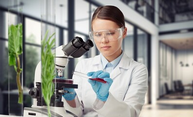 Scientist with test tubes and green plants, research concept.