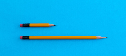 Long and short pencils on blue background